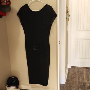 Black dress with scalloped sleeves and belted bow around waist.